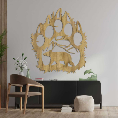 Kézzel faragott dekoráció, amely egy hegyvonulat alatt sétáló medvét ábrázol.