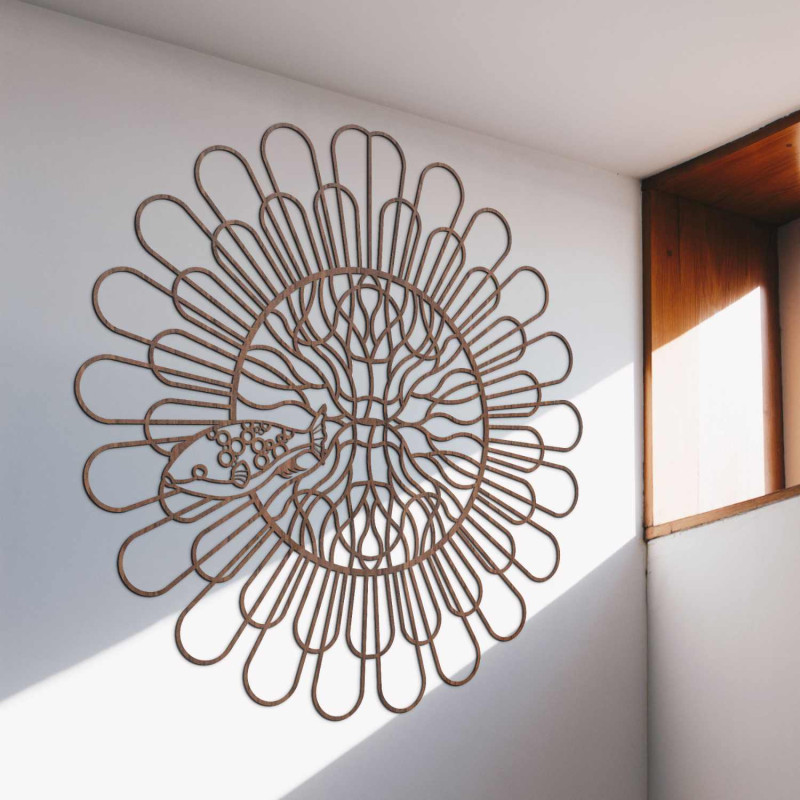 Fekete fa mandala halakkal egy fehér falon egy modern lakásban