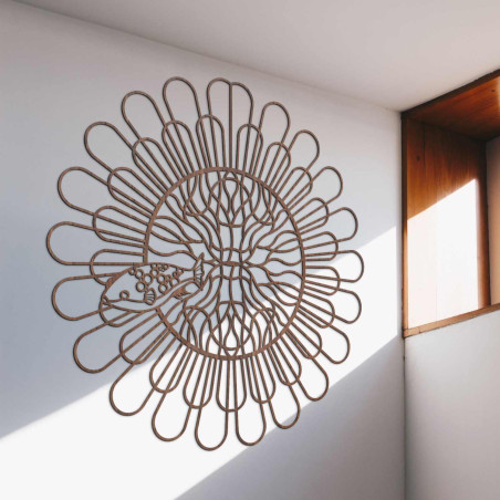 Fekete fa mandala halakkal egy fehér falon egy modern lakásban